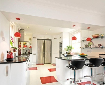 Weiße Küche mit roten Elementen.
