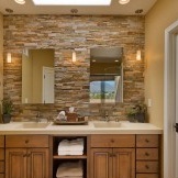 Der Bereich der Spiegel und Waschbecken wird mit hellem Stein hervorgehoben.
