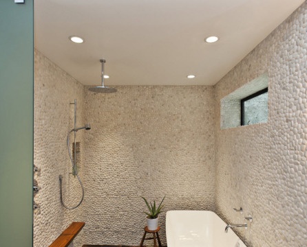 Kieselsteine ​​an der Wand im Badezimmer, bedeckt mit weißer Farbe