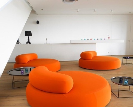 Entspannungsbereich für Familien mit runden Möbeln in leuchtendem Orange