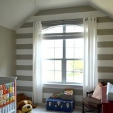 Eine Wand des Kinderzimmers ist mit breiten Querstreifen verziert