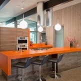 Bartheke mit orangefarbener Arbeitsplatte - ein heller Akzent des Kücheninterieurs