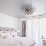 Weißes Schlafzimmer mit lila Vorhängen