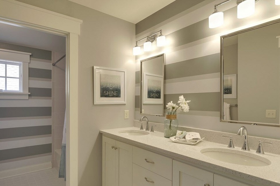 Das originelle helle Design des Badezimmers mit breiten Querstreifen an den Wänden passt zum Ton des gesamten Innenraums