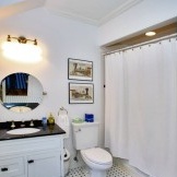 Interior hitam dan putih bilik mandi kecil di mana nada utama berwarna putih
