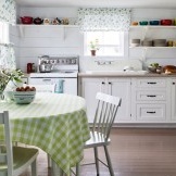 Als Accessoire buntes Geschirr und eine Blumenvase im Inneren einer rustikalen Küche