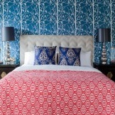 Tapete im Schlafzimmer hallt mit dekorativen Kissen auf dem Bett wider