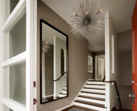 Ein Spiegel in einem braunen Rahmen neben der Treppe