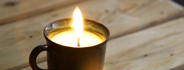 Kerze in einer Tasse angezündet