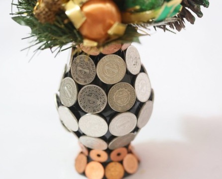 Vase mit Münzen verklebt, mit einem Blumenstrauß