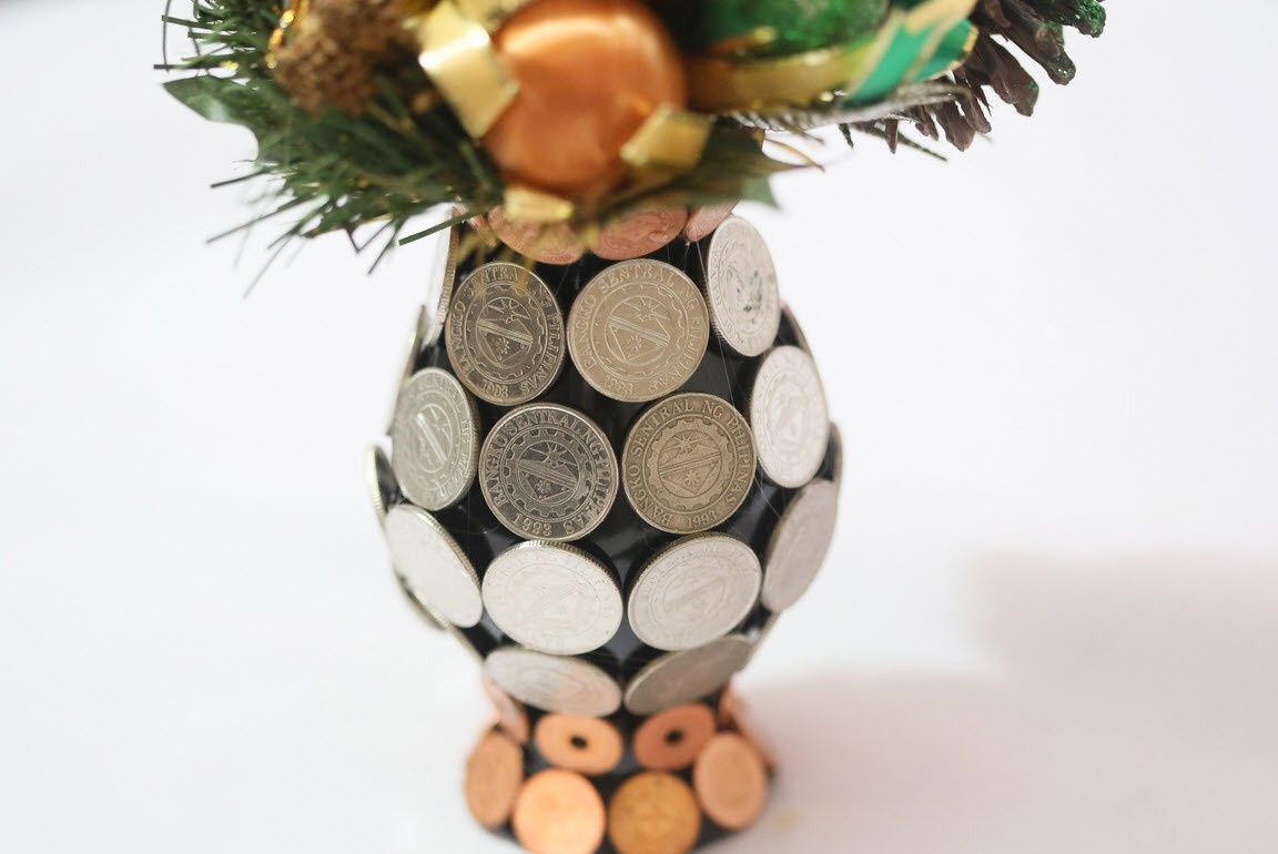 Vase mit Münzen verklebt, mit einem Blumenstrauß